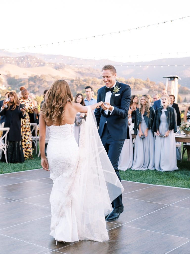 candid wedding photo of bride and groom dancing during their first dance at a sunstone winery wedding venue